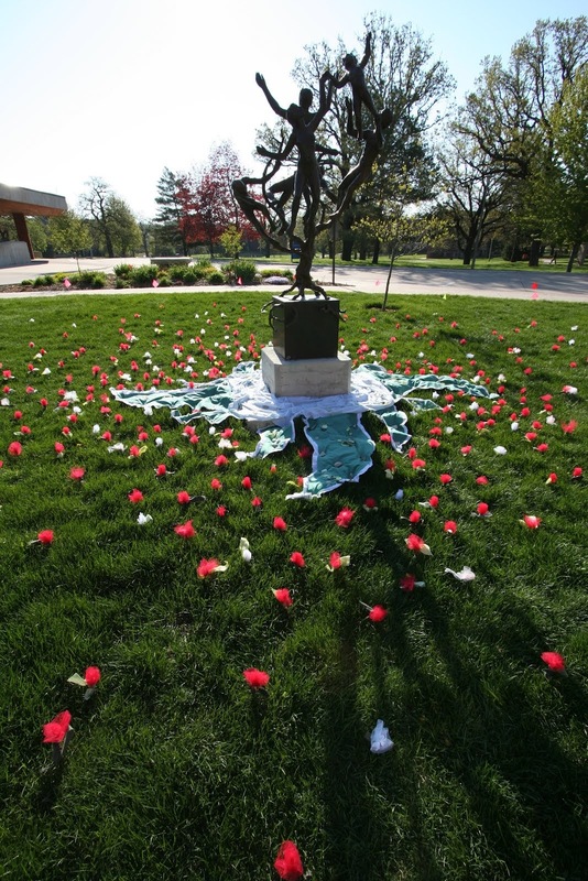 Flowers are arranged around the Tree of Life statue, using a fabric wheel.JPG