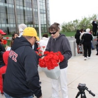 Handing out flowers to represent the 389 workers detained in the raid.JPG