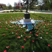 Flowers are arranged around the Tree of Life statue, using a fabric wheel