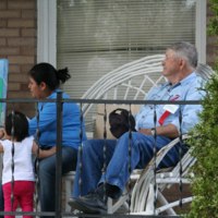 Woman, child, man sitting on porch